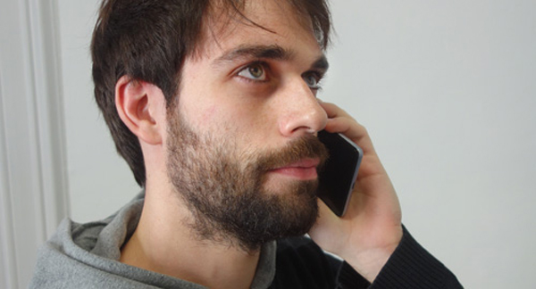 A photo of a man speaking on a mobile.